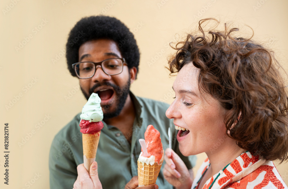 Happy friends sharing ice cream in front of wall Happy friends sharing ice cream in front of wall