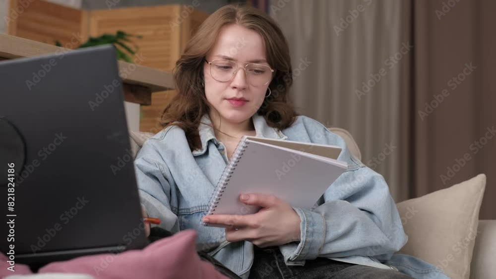 Intently analyzing her notes, a woman works from home, glasses perched on her nose. This depicts the balance many seek between life and work. Intently analyzing her notes, a woman works from home, glasses perched on her nose. This depicts the balance many seek between life and work.