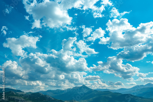 Spectacular natural landscape of a mountain range covered with cumulus clouds against a bright blue sky 
