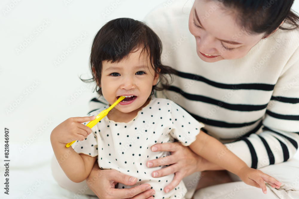 mother brushing her daughters teeth. happy baby with tooth brush mother brushing her daughters teeth. happy baby with tooth brush