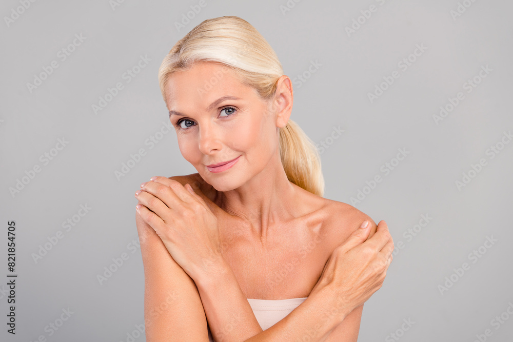 Portrait of happy calm peaceful pensioner woman hug herself enjoy soft fresh skin peeling scrub isolated on gray color background Portrait of happy calm peaceful pensioner woman hug herself enjoy soft fresh skin peeling scrub isolated on gray color background