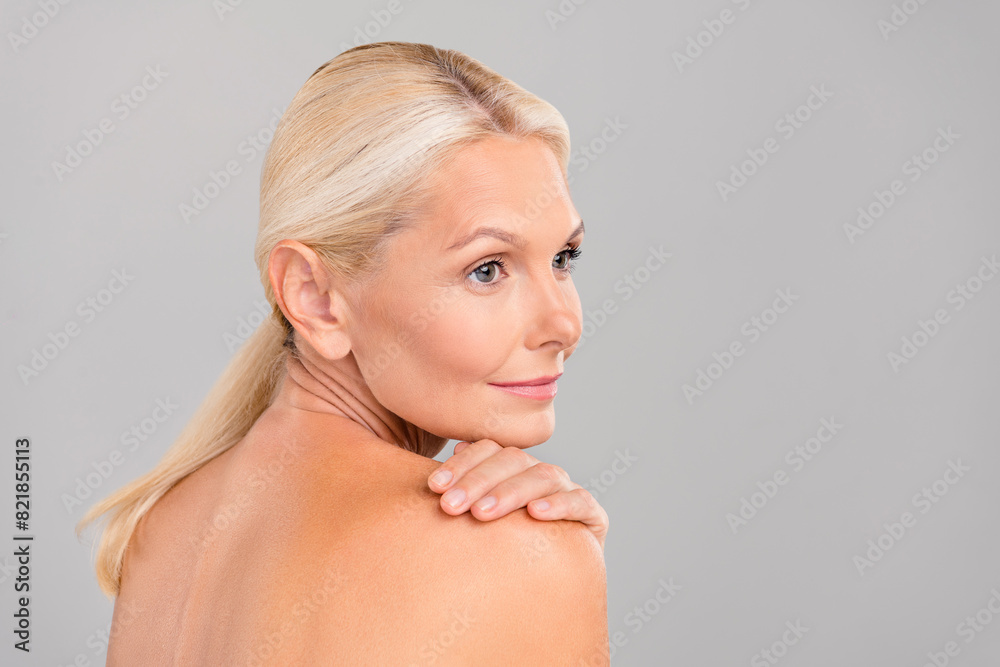 Profile side photo of pensioner lady touch body soft pure skin apply bath lotion isolated on grey color background Profile side photo of pensioner lady touch body soft pure skin apply bath lotion isolated on grey color background