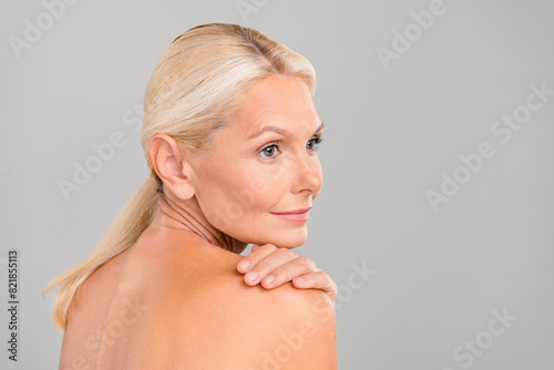 Profile side photo of pensioner lady touch body soft pure skin apply bath lotion isolated on grey color background