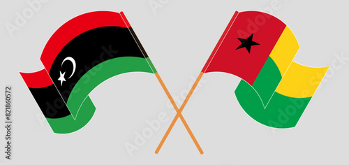 Crossed and waving flags of Libya and Guinea-Bissau photo