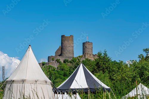 Burg Münzenberg in der Wetterau bei schönem Wetter und blauem Himmel mit der vorgelagerten Zeltstadt eines mittelalterlichen Marktes