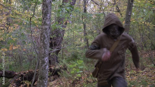 A maniac or criminal in a mask runs through the forest