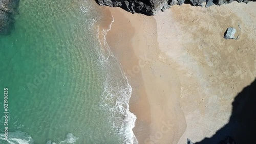 Beautiful Beach Cove with Tranquil Waters in Slow Motion, Aerial Ascending Drone in Cornwall, UK. photo