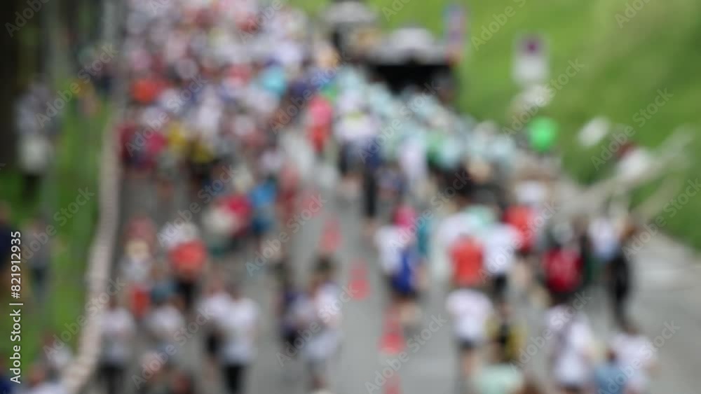Large group of people running up and down the hill, blurred background