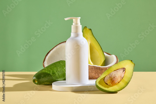 Mock up for advertising with blank label shampoo bottle, sample for adding packaging of product extracted from avocado and coconut, featured in the middle of yellow table on pastel green background © Tuan  Nguyen 