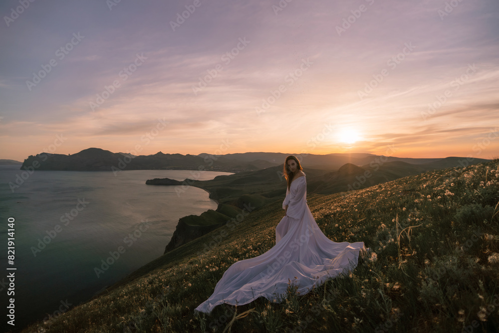 A woman stands on a hill overlooking a body of water A woman stands on a hill overlooking a body of water