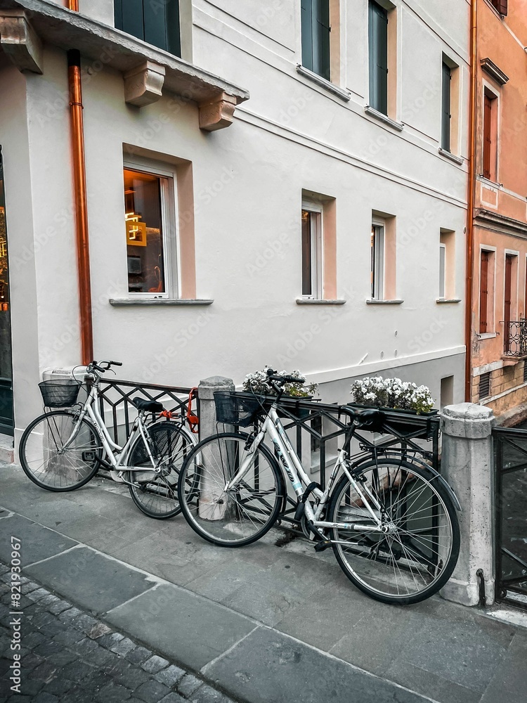 Row of bicycles parked on a bridge against a building in Venice, Italy Row of bicycles parked on a bridge against a building in Venice, Italy