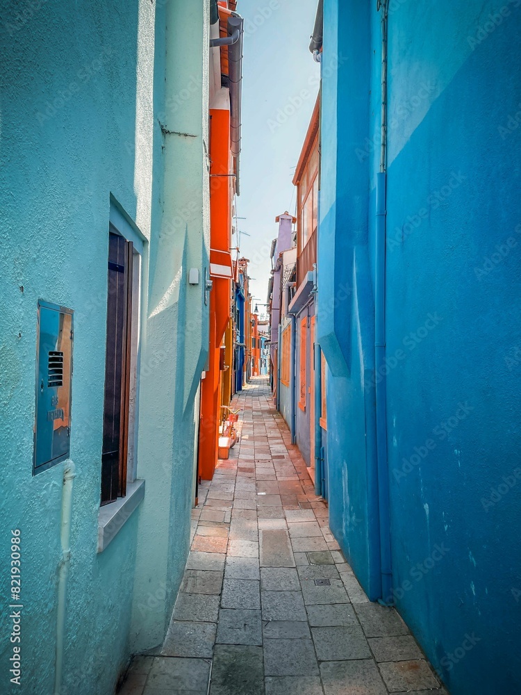 Fototapeta premium Vertical of a narrow street between colorful houses on Burano, Italy