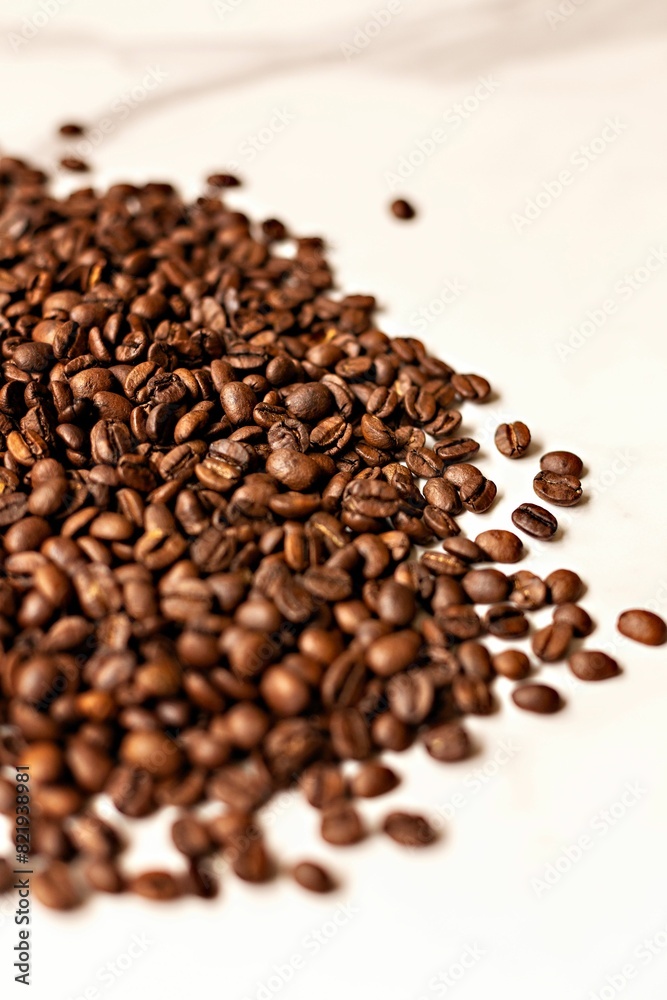 Heap of freshly roasted coffee beans on a bright white background. Heap of freshly roasted coffee beans on a bright white background.