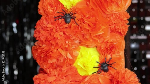 Putting plastic spiders on cempasuchil flower garland for Halloween. photo
