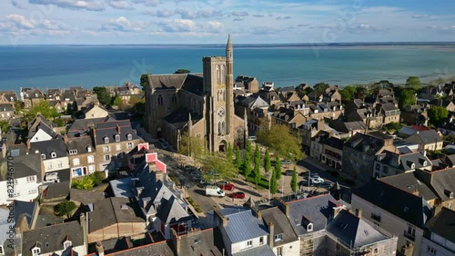 Saint-Meen church with sea in background, Cancale, Brittany in France. Aerial drone orbiting photo