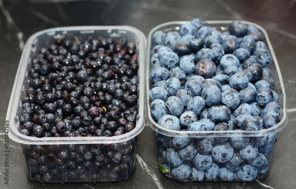 Blueberries and bilberries in boxes on the table as a concept of vitamin and antioxidants, super food and healthy lifestyle. Blueberries and bilberries in boxes on the table as a concept of vitamin and antioxidants, super food and healthy lifestyle.