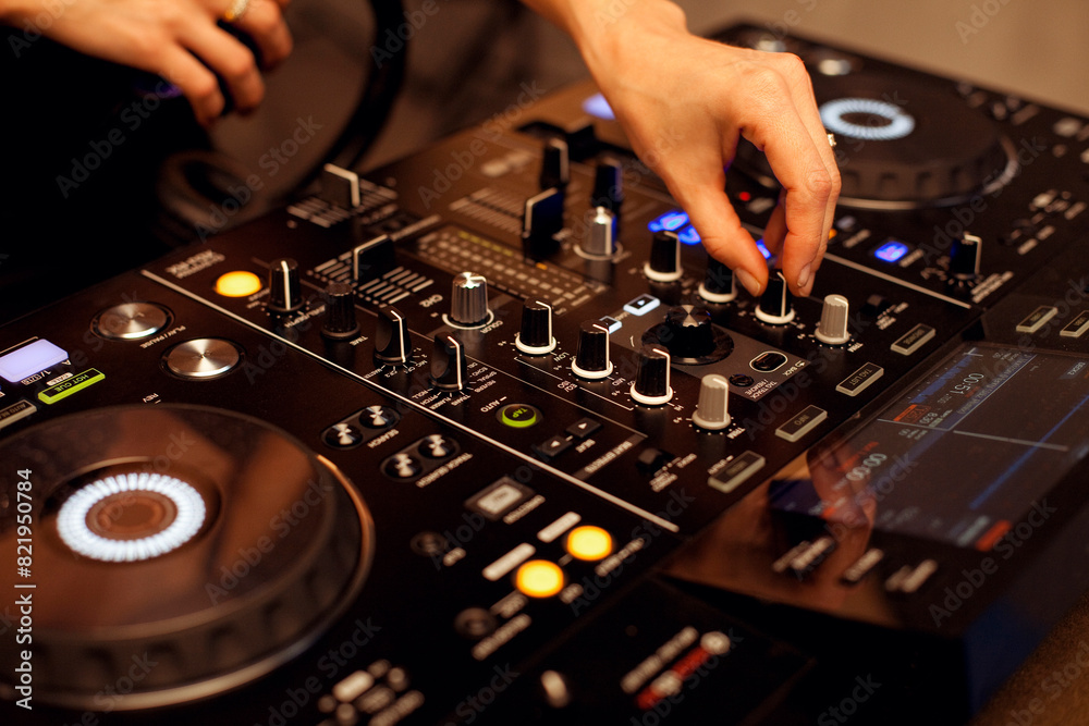 Close up portrait of female disc jockey hands mixing tracks on professional sound mixer, playing music at nightclub. Dj, disco, discotheque concept. Close up portrait of female disc jockey hands mixing tracks on professional sound mixer, playing music at nightclub. Dj, disco, discotheque concept.