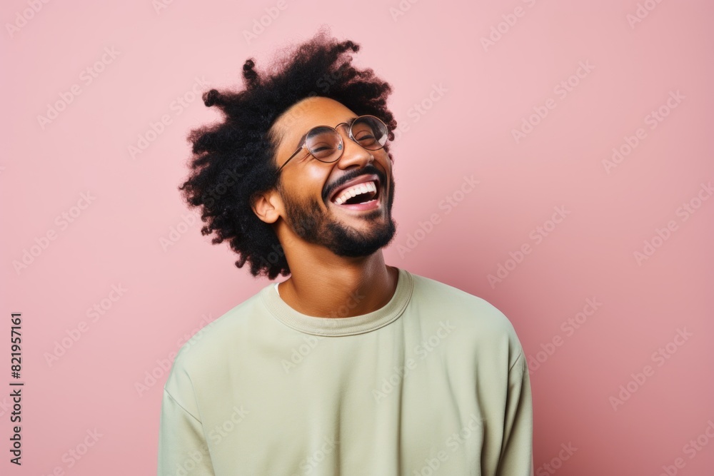 Portrait of a glad afro-american man in his 20s laughing isolated on solid pastel color wall