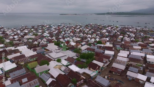 Aerial view of crowded fishing village with boats and houses by the sea, Bungin Island, Sumbawa, Indonesia. photo