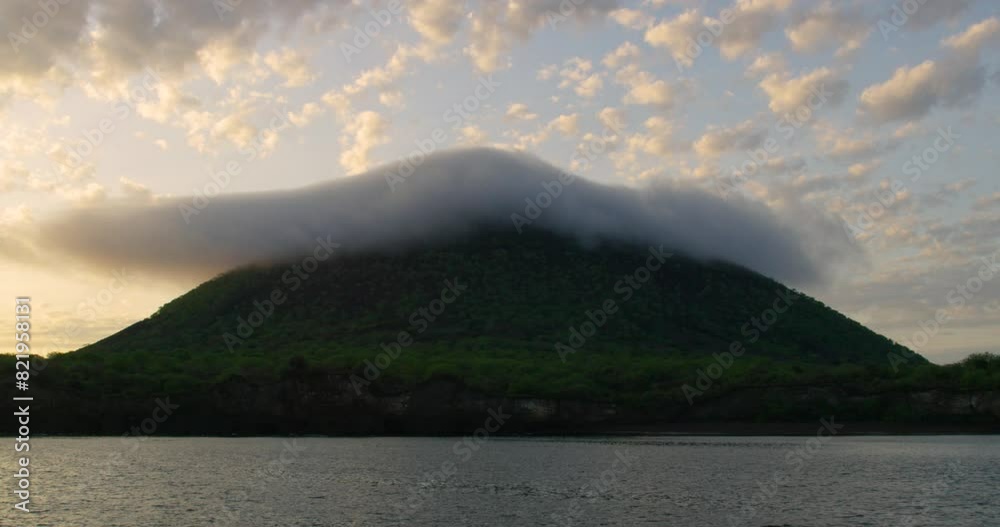 Green tropical mountain with peak covered with thick cloud at sunset. Green tropical mountain with peak covered with thick cloud at sunset.