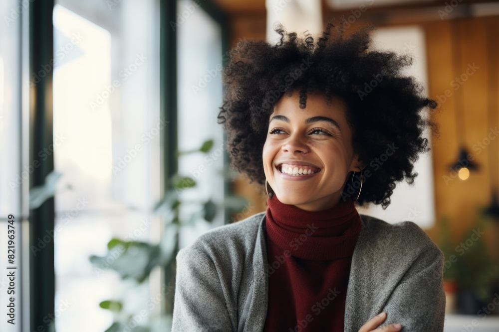 Fototapeta premium Portrait of a satisfied afro-american woman in her 30s laughing in scandinavian-style interior background