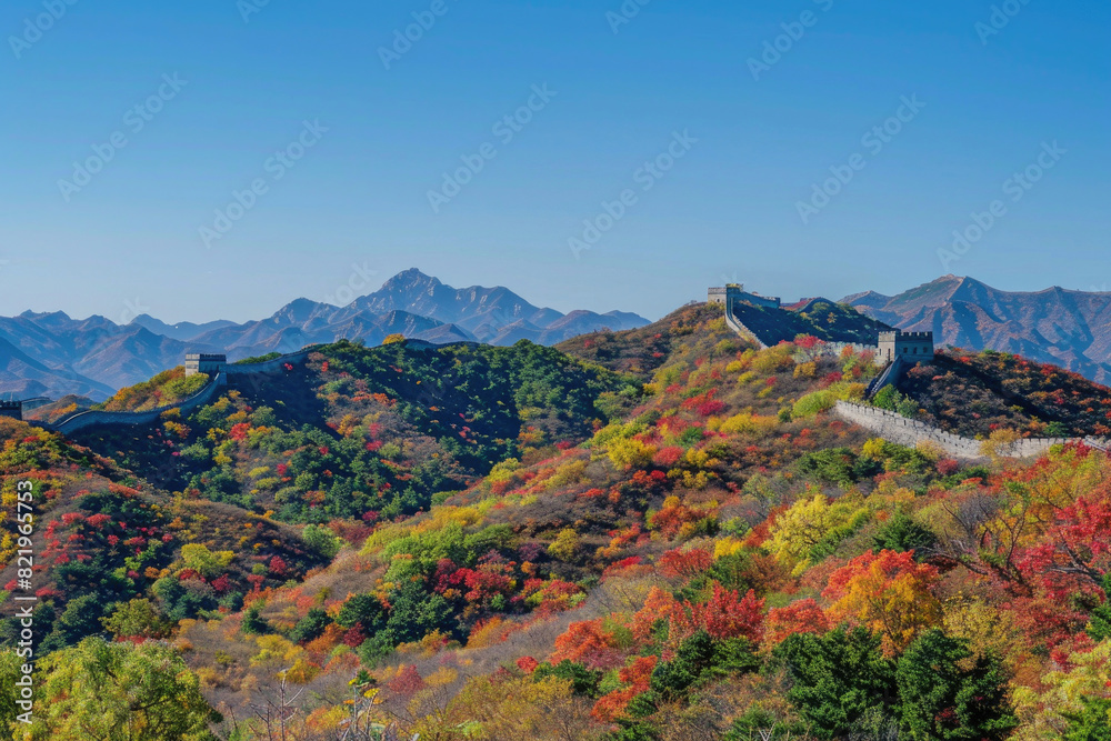 The Great Wall winding through vibrant autumn foliage under a clear blue sky