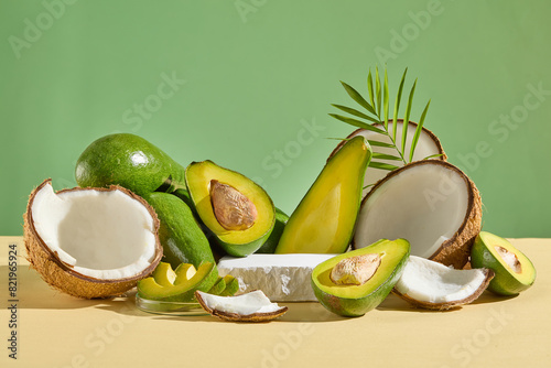 Unique photograph of avocado and coconut theme with vacant platform of plaster in center for presentation on green background. Vacant space for adding text or designing elements