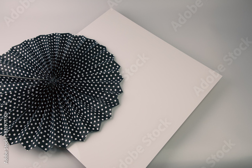 black and white polka dot paper fan sitting on top of a card