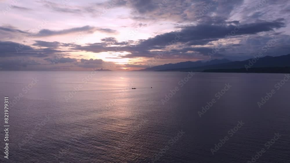 Aerial view of serene sunset over ocean with boats and mountains, Borong, Flores, Indonesia. Aerial view of serene sunset over ocean with boats and mountains, Borong, Flores, Indonesia.