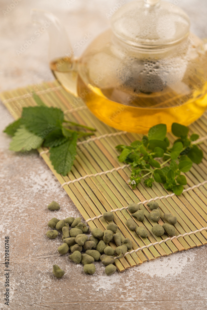 Green oolong tea with herbs in glass on brown concrete. Side view, selective focus. Green oolong tea with herbs in glass on brown concrete. Side view, selective focus.