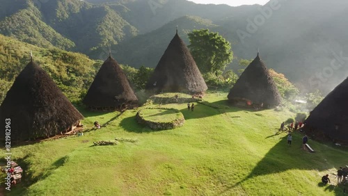 Aerial view of traditional village with conical huts nestled among mountains in Wae Rebo, Flores, Indonesia. photo