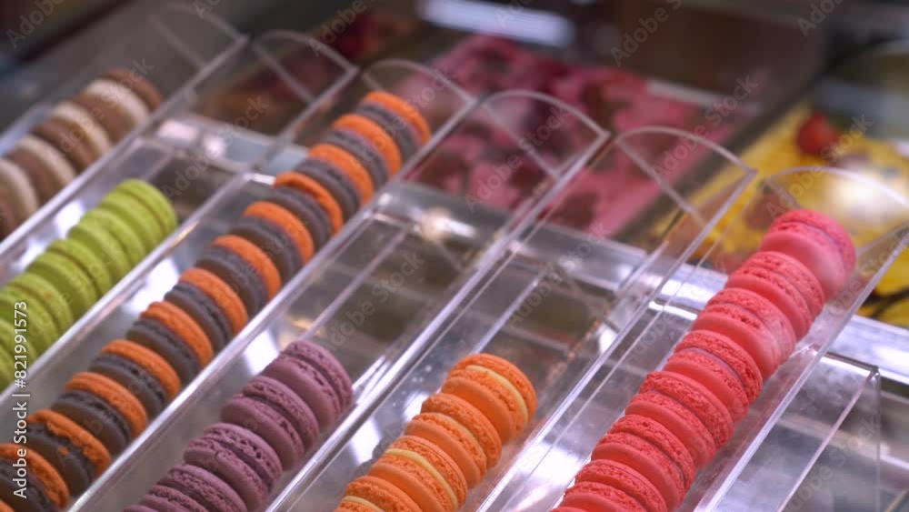 Rows of colorful macaroons on display in small dessert shop.