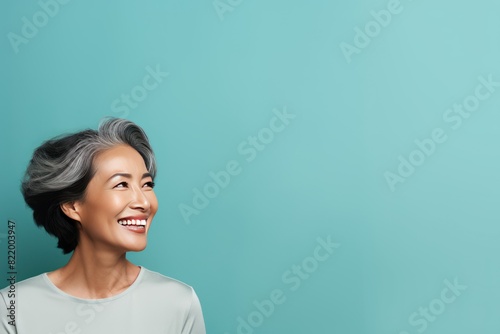 Aqua Background Happy Asian Woman Portrait of Beautiful Older Mid Aged Mature Smiling Woman good mood Isolated Anti-aging Skin Care Face Beauty Product Banner 