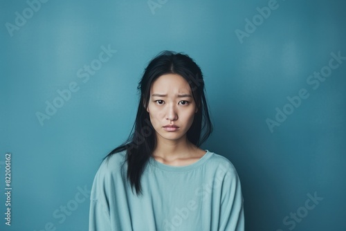 Azure background sad Asian Woman Portrait of young beautiful bad mood expression Woman Isolated on Background depression anxiety fear burn  © Zickert