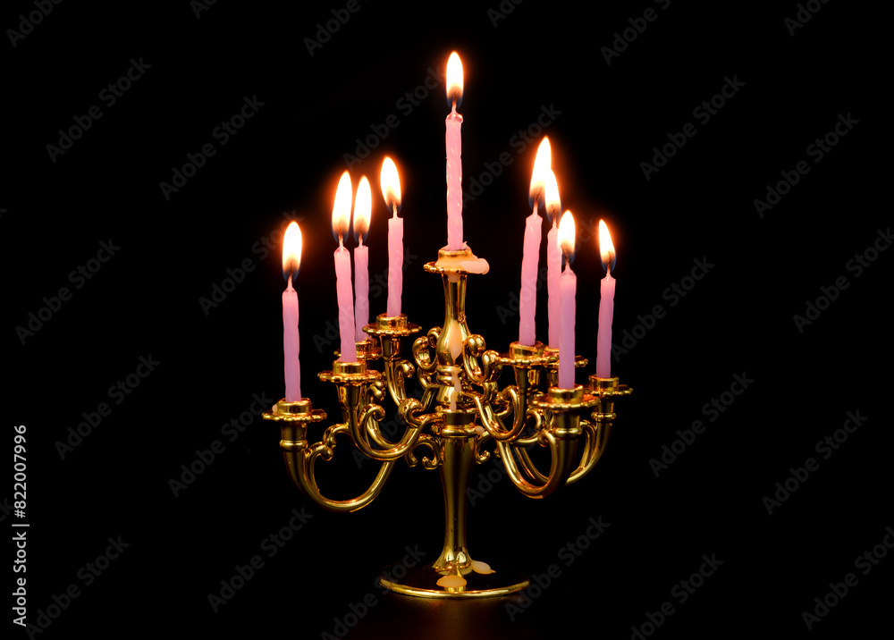 Gold candelabra with many purple burning candles isolated on black background. Gold candelabra with many purple burning candles isolated on black background.