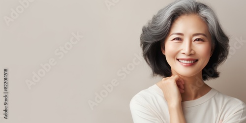 Beige Background Happy Asian Woman Portrait of Beautiful Older Mid Aged Mature Smiling Woman good mood Isolated Anti-aging Skin Care Face Beauty Product 