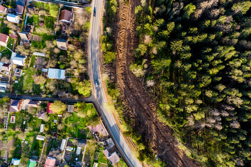 Aerial view of a clearing on the outskirts of the forest, laying a gas pipeline in a dacha area