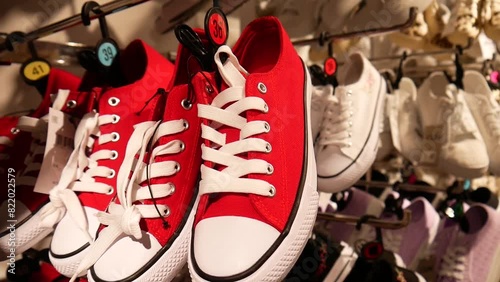 Close-up of red pair of sneakers hanging with many others in a shoe boutique photo