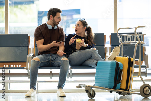 couple arguing about their vacation. Couple fights at the airport while waiting for their plane. Couple turn their backs on each other angry. Young tourists arguing because of forgotten things.