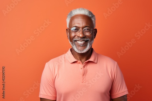 Coral Background Happy black american independant powerful man. Portrait of older mid aged person beautiful Smiling boy Isolated on Background ethnic