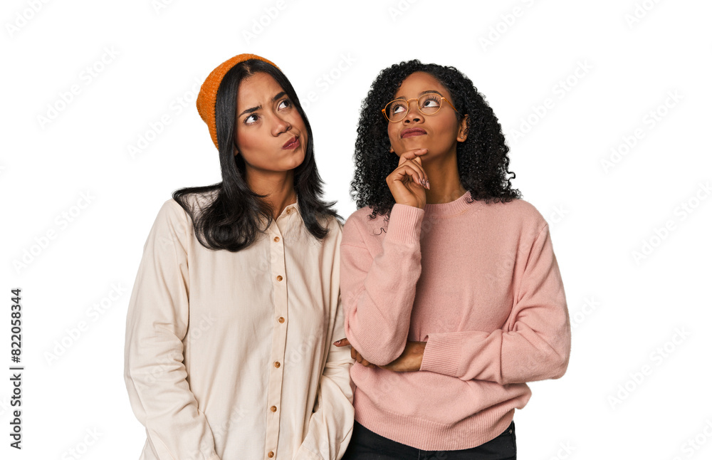Young Latin friends together in studio thinking and looking up, being reflective, contemplating, having a fantasy. Young Latin friends together in studio thinking and looking up, being reflective, contemplating, having a fantasy.