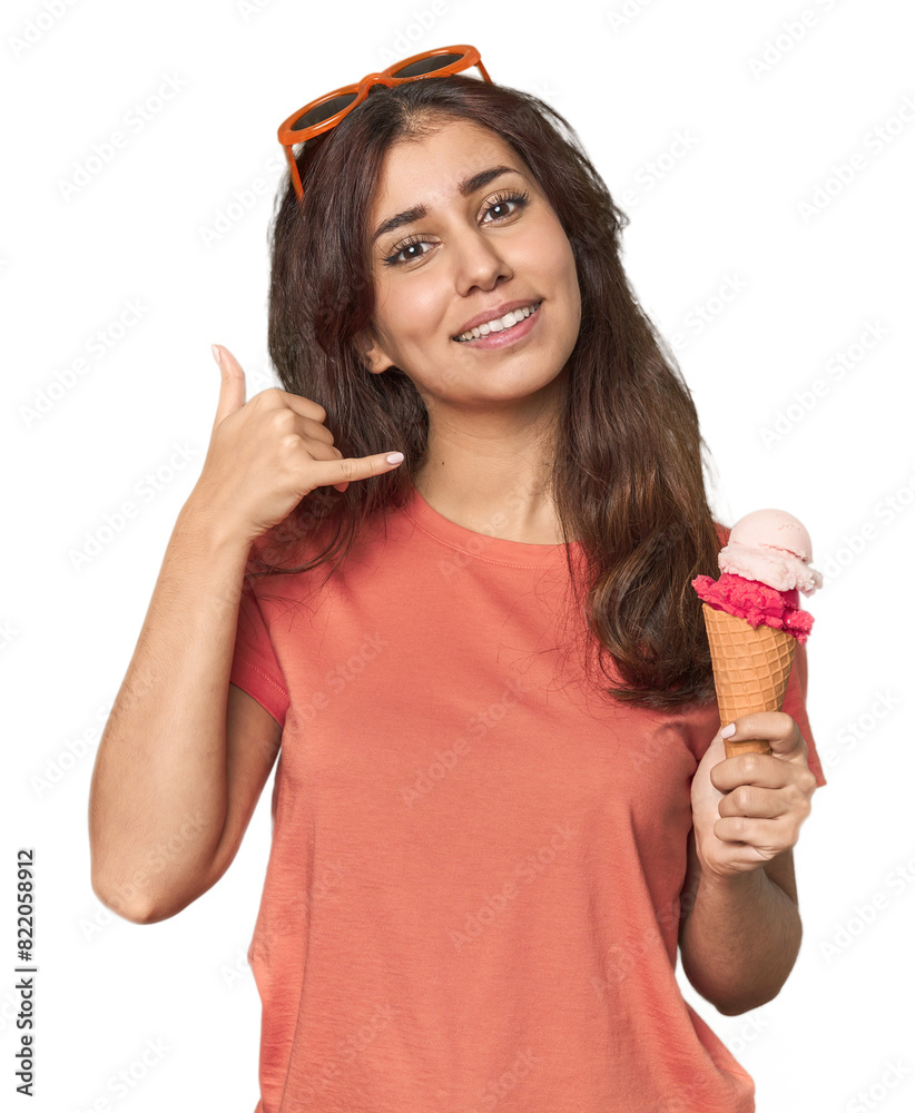 Middle Eastern woman eating ice cream showing a mobile phone call gesture with fingers. Middle Eastern woman eating ice cream showing a mobile phone call gesture with fingers.