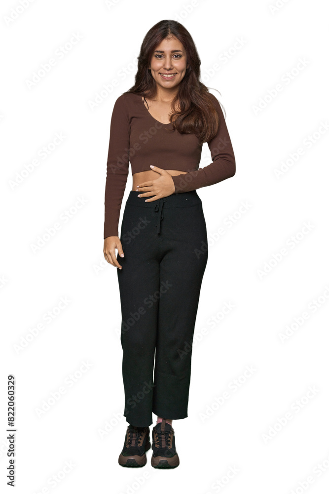 Middle Eastern woman, full body studio touches tummy, smiles gently, eating and satisfaction concept. Middle Eastern woman, full body studio touches tummy, smiles gently, eating and satisfaction concept.