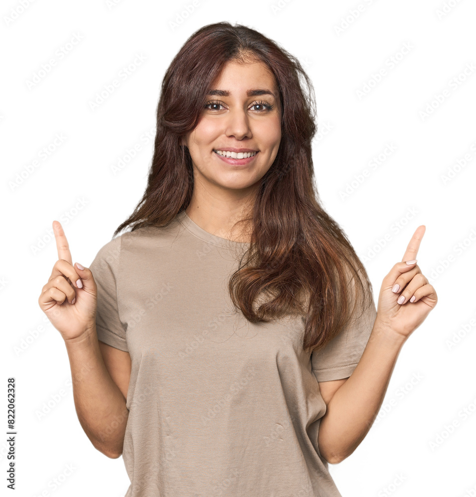 Middle Eastern woman in studio indicates with both fore fingers up showing a blank space. Middle Eastern woman in studio indicates with both fore fingers up showing a blank space.