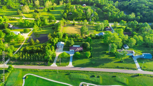 Foto Golf course country club in rural area with low density housing, lush greenery t