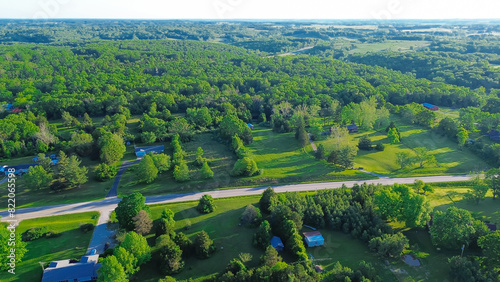 Country road US-60 BUS in rural Mountain Grove Missouri through lush greenery trees acreage  meadows and farm houses with ponds in agricultural area  peaceful countryside in Midwest  aerial view