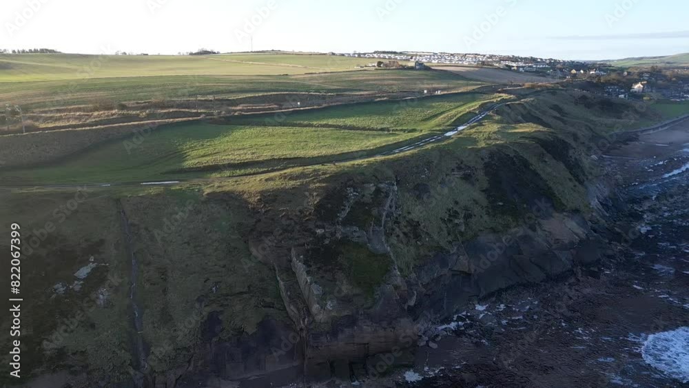 Landscape aerial view of coastal highlands by foam splashing sea waves in Caithness, Scotland Landscape aerial view of coastal highlands by foam splashing sea waves in Caithness, Scotland
