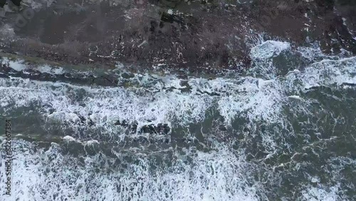 Drone flyover green highlands by splashing sea waves in Caithness, Scotland photo