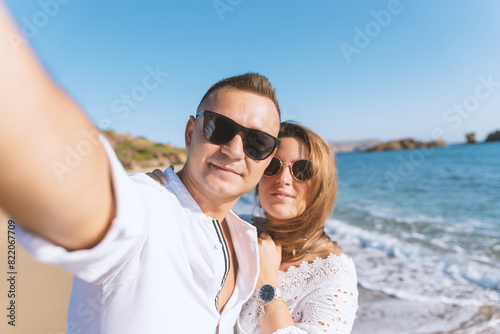 Young happy couple taking selfie on the beach. Summer vacations concept.