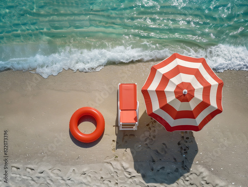 Red and white beach umbrella, chair, and float on sandy shore with ocean waves. Aerial view. Summer vacation concept. Generative AI